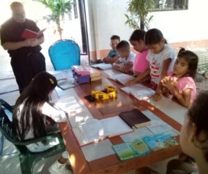 Students of "Mi Pequeña Lucecita" after school while Pastor David Ernst reads for them a Bible passage.