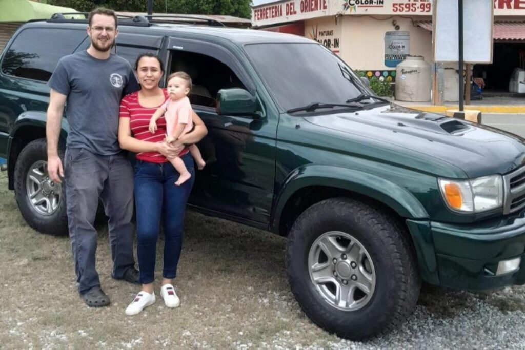 Benjamin, Scarlett, and Jakko Tino posing in front of the new family's car